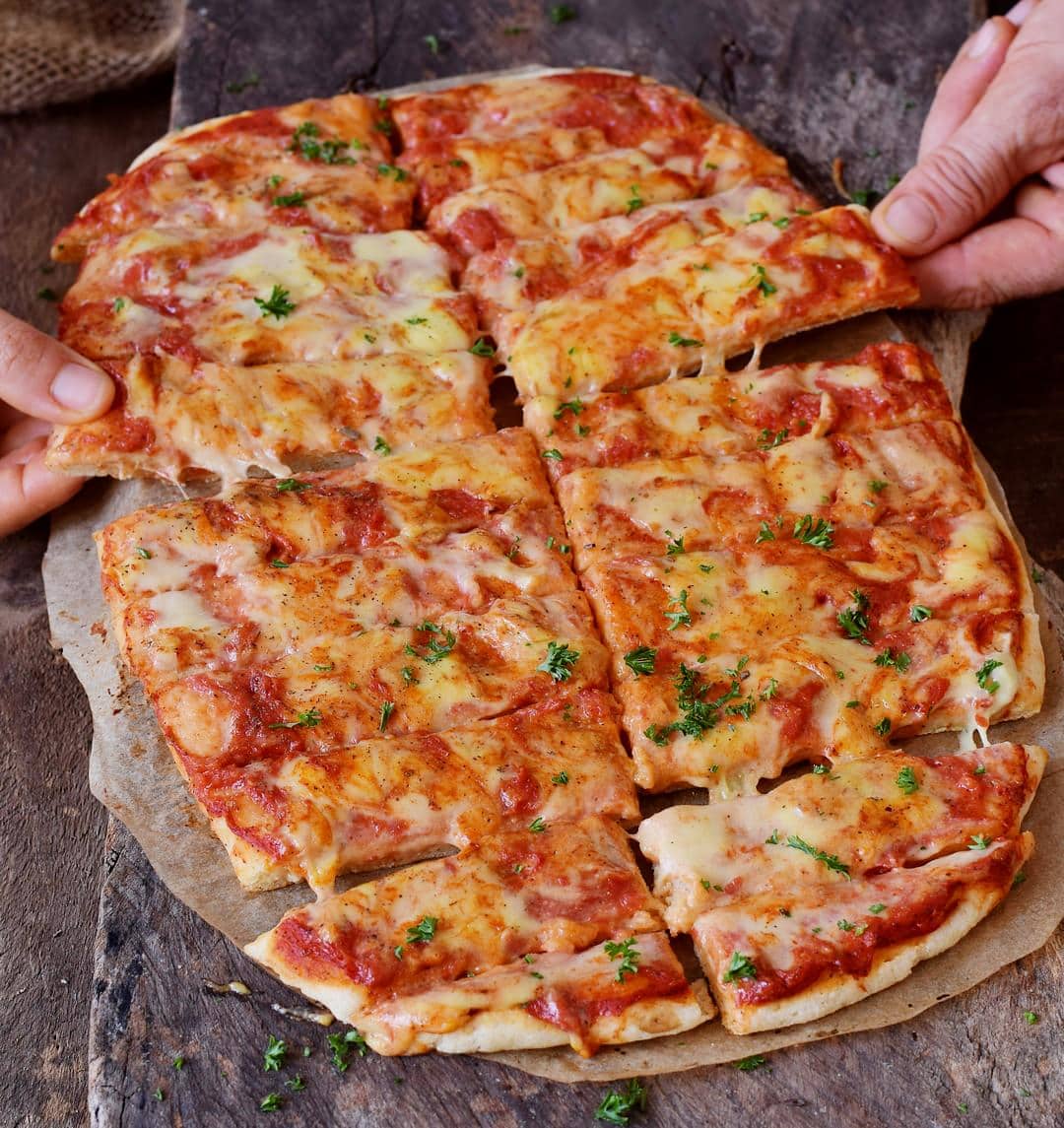 Pizza Stücken mit Tomatensauce. Vegane Käsesauce obendrauf!