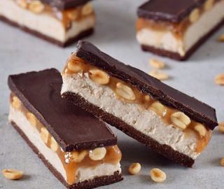 Vegane Snickers mit Schokolade, Creme, Erdnüssen und Karamell. Das Rezept ist glutenfrei, ohne tierische Produkte (pflanzlich, milchfrei, eifrei), gesund und einfach zu machen.