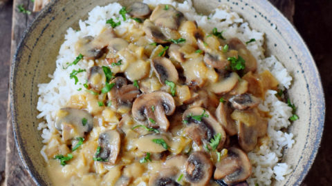 Pilz Stroganoff mit Reis in einer Schüssel mit Holzlöffel