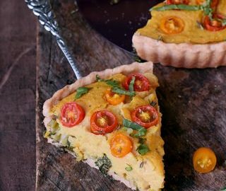 Glutenfreie vegane Quiche ohne Eier mit Gemüse Kuchenstück auf Tortenheber