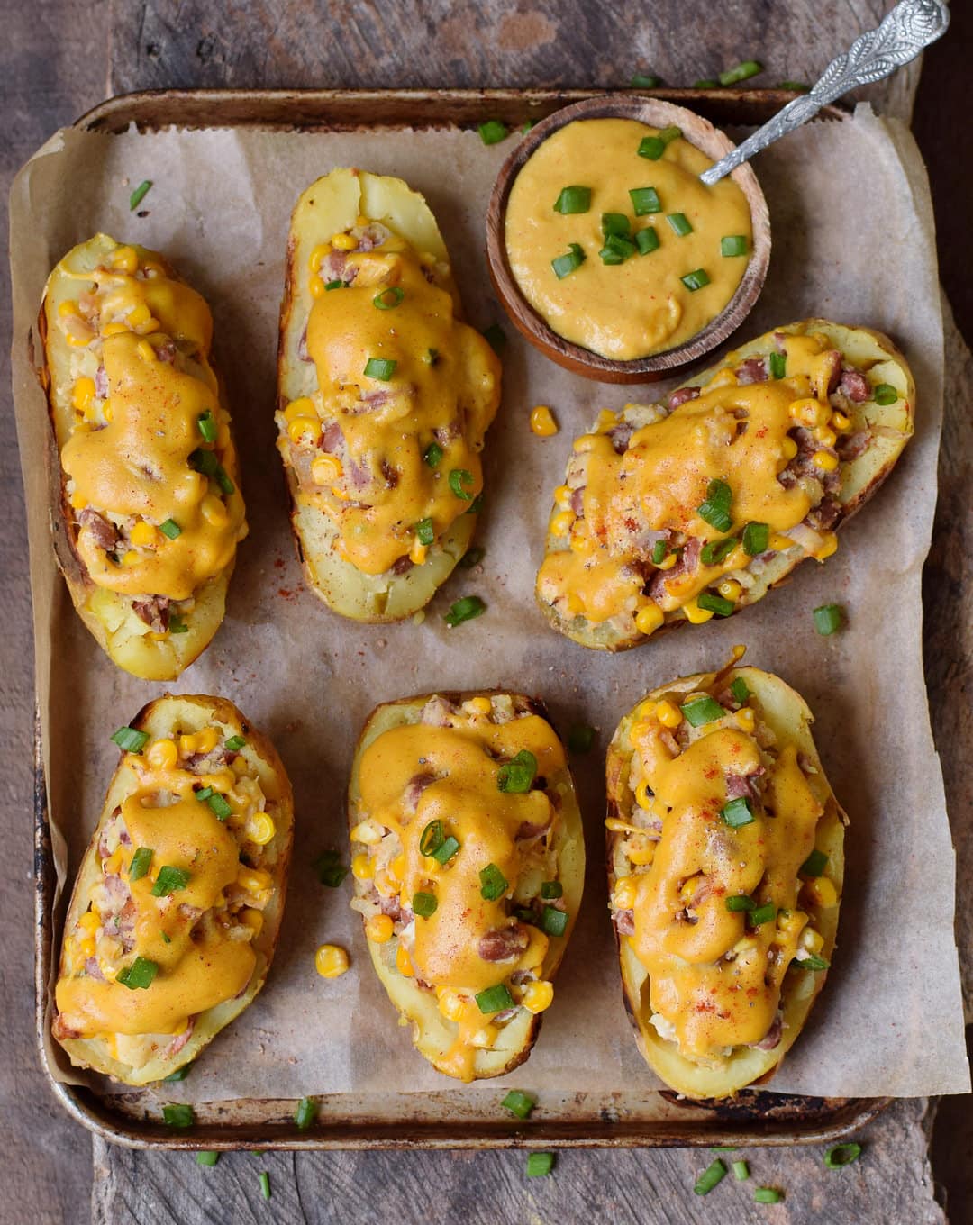 Gefüllte Ofenkartoffeln mit Gemüse und veganem Käse auf einem Backblech