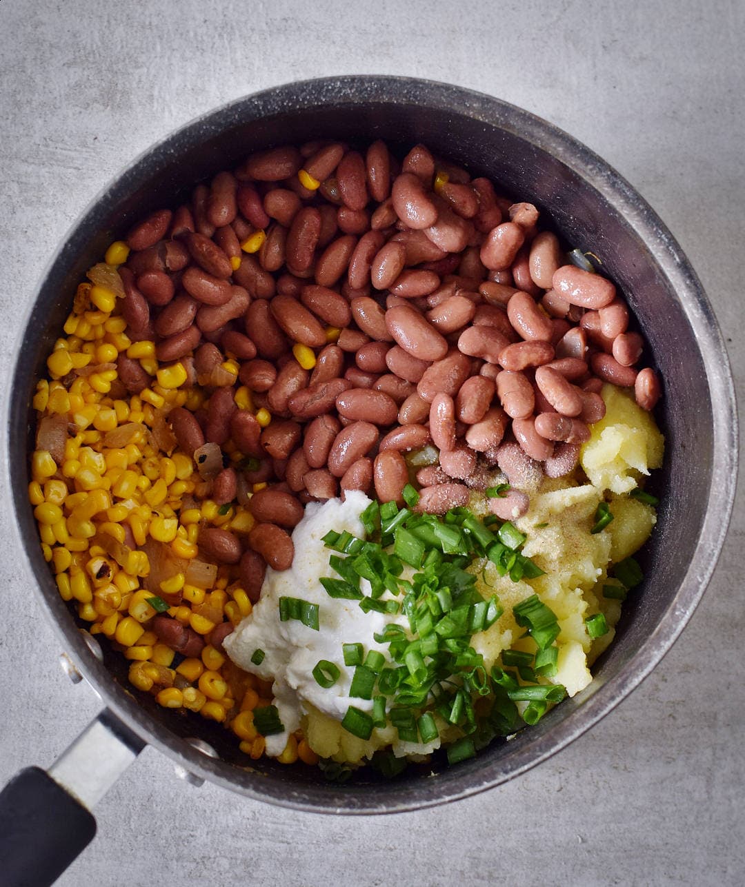 Gemüse und Bohnen für gefüllte Ofenkartoffeln in einem Topf