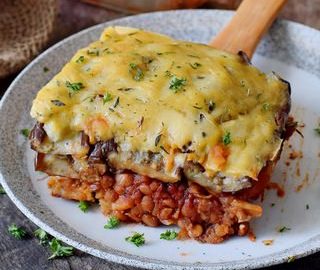 Linsen Moussaka mit Auberginen geschichtet und Bechamelsauce auf einem Teller 320x320