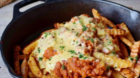 Chili Cheese Fries in schwarzer Pfanne mit veganem Käse
