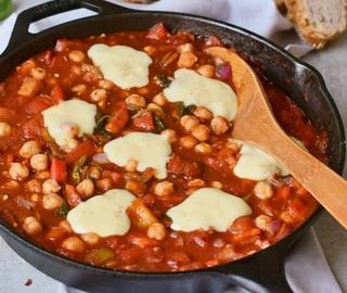 Tomaten-Eintopf mit Kichererbsen in einer schwarzen Pfanne