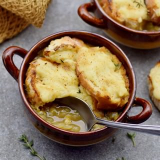 Gesunde Suppe mit Zwiebeln und veganem Käsebaguette