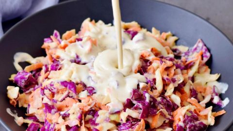 Veganes Dressing wird über Coleslaw (amerikanischer Krautsalat) gegossen