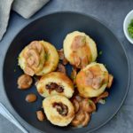 4 Kartoffelklöße in schwarzer Schüssel mit Pilzsoße