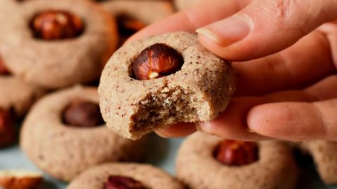 Haselnussplätzen auf Teller, Hand hält eins