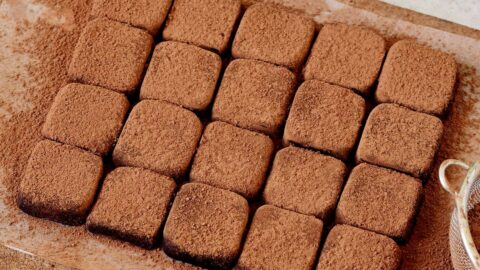 20 rechteckige Schokotrüffel auf einem Holzbrett