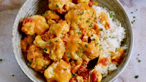 Blumenkohl Curry mit Reis in Schale mit Löffel