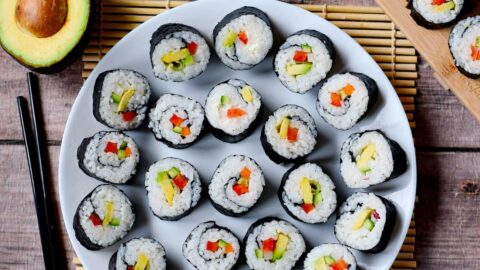 veganes Sushi auf weißem Teller von oben