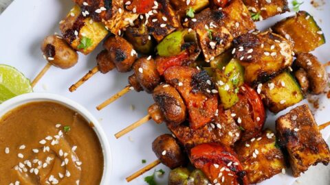 Tofu und Gemüsespieße mit Erdnusssauce auf weißem Teller