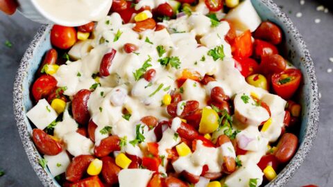 Cremiges weißes Dressing wird über Kidneybohnen Salat gegossen