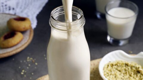 Selbstgemachte Hanfmilch wird in Glasflasche gegossen