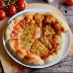 selbstgemachte italienische Pizza mit Tomatensoße und veganem Käse auf weißem Teller