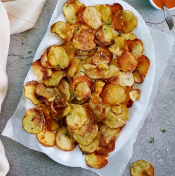 selbstgemachte Kartoffelchips auf weißem Teller
