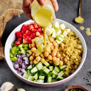 Zitronendressing wird über Quinoa Salat gegossen