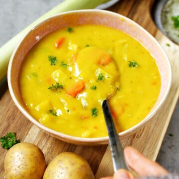vegane Kartoffel-Lauch-Suppe in Schale mit Löffel