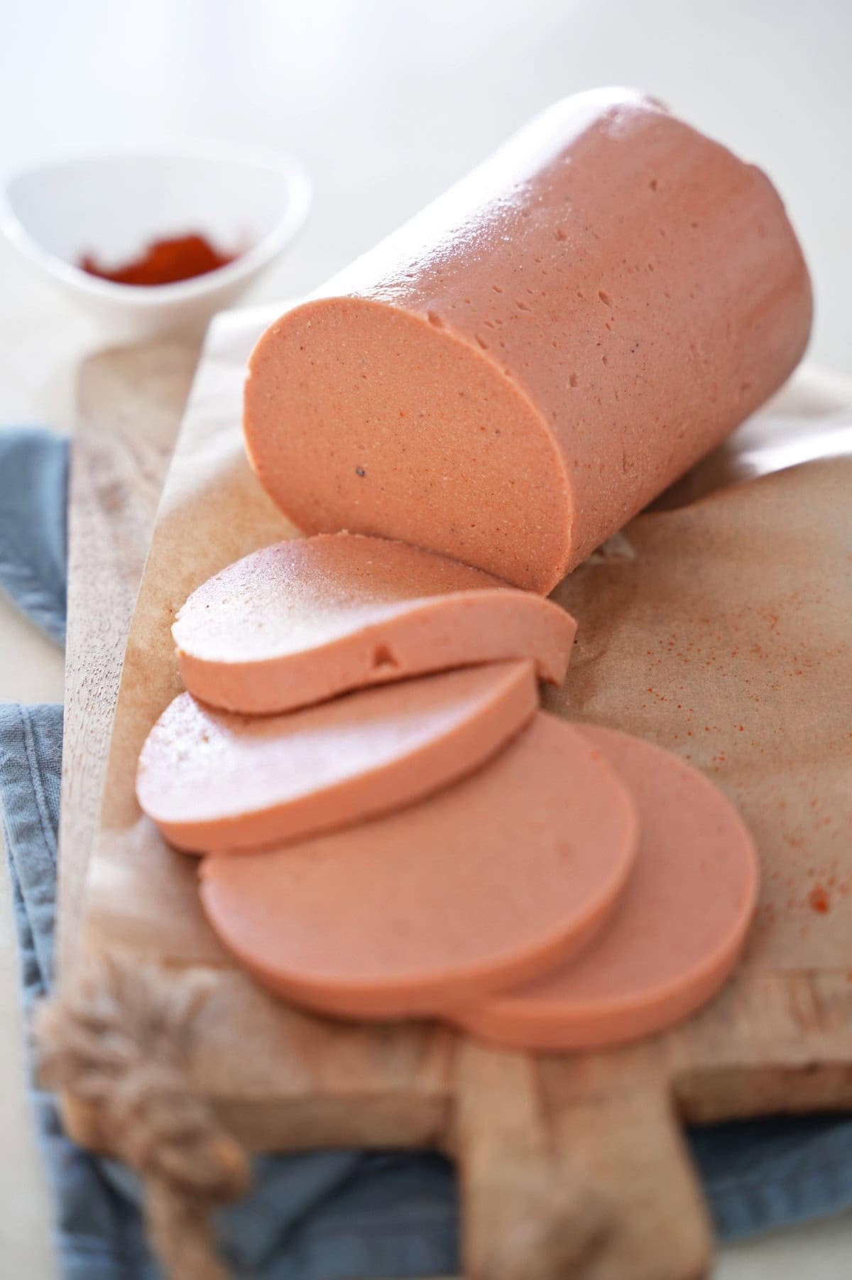 vegane Lyoner Wurst aufgeschnitten auf Holzbrett