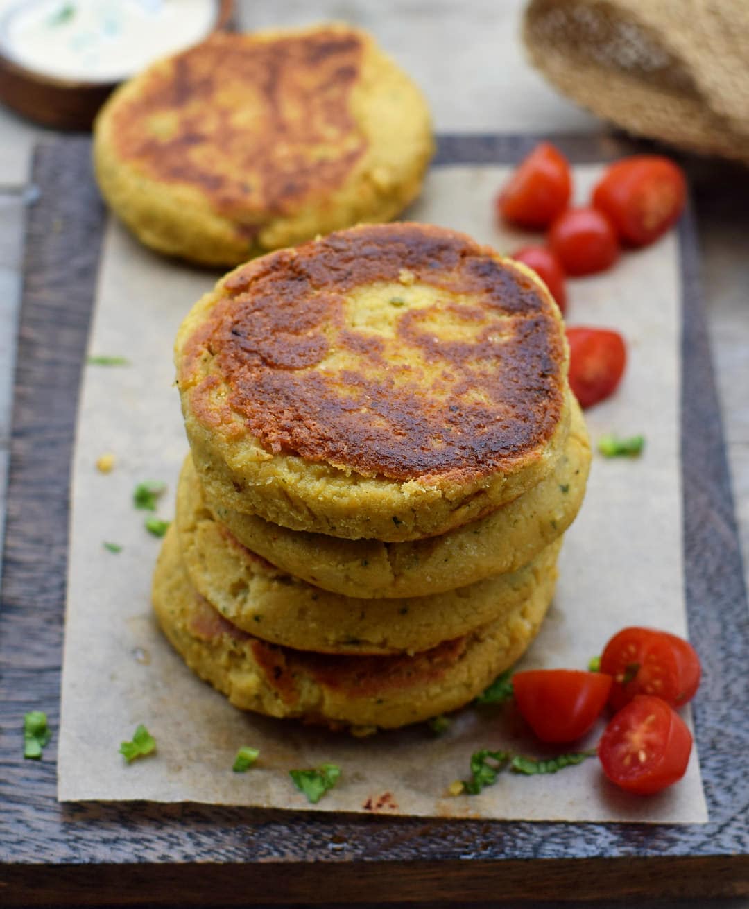 stack of cauliflower cakes with cherry tomatoes on the side
