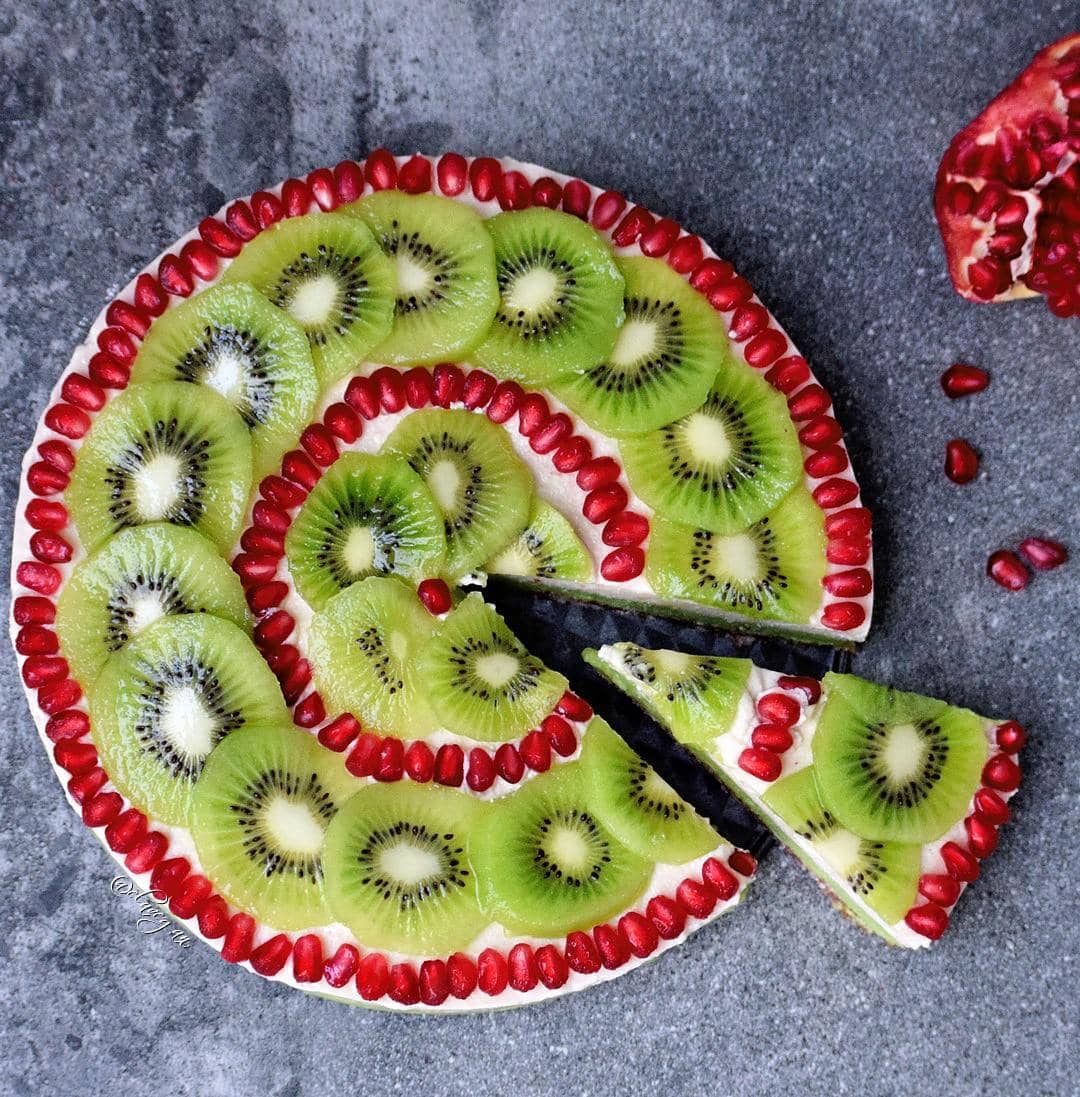 vegan fruit pie with kiwi and pomegranate and a slice cut out