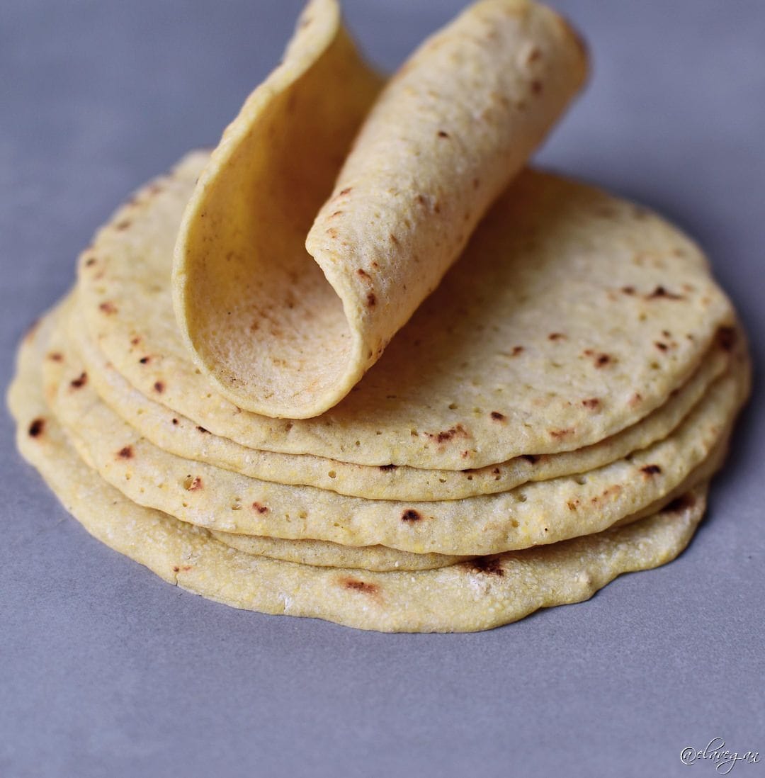 Stack of gluten free wraps with the top one rolled