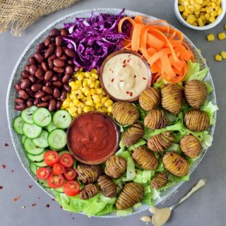 This healthy vegan lunch bowl with Hasselback potatoes is filling, easy to make and delicious. The buddha bowl is rich in plant-based protein, gluten-free and grain-free. Two easy and tasty sauce recipes included