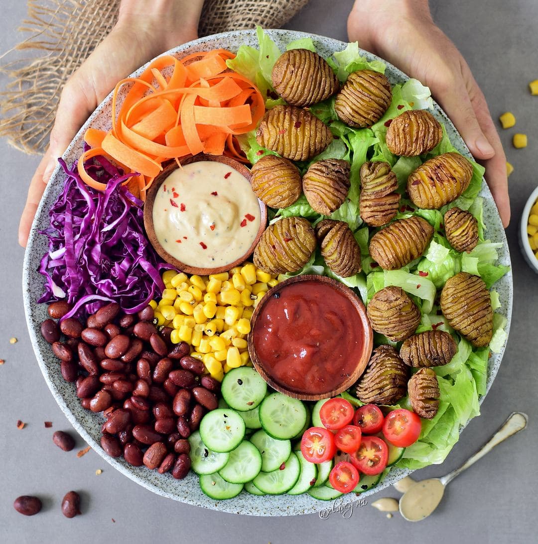 This healthy vegan lunch bowl with Hasselback potatoes is filling, easy to make and delicious. The buddha bowl is rich in plant-based protein, gluten-free and grain-free. Two easy and tasty sauce recipes included