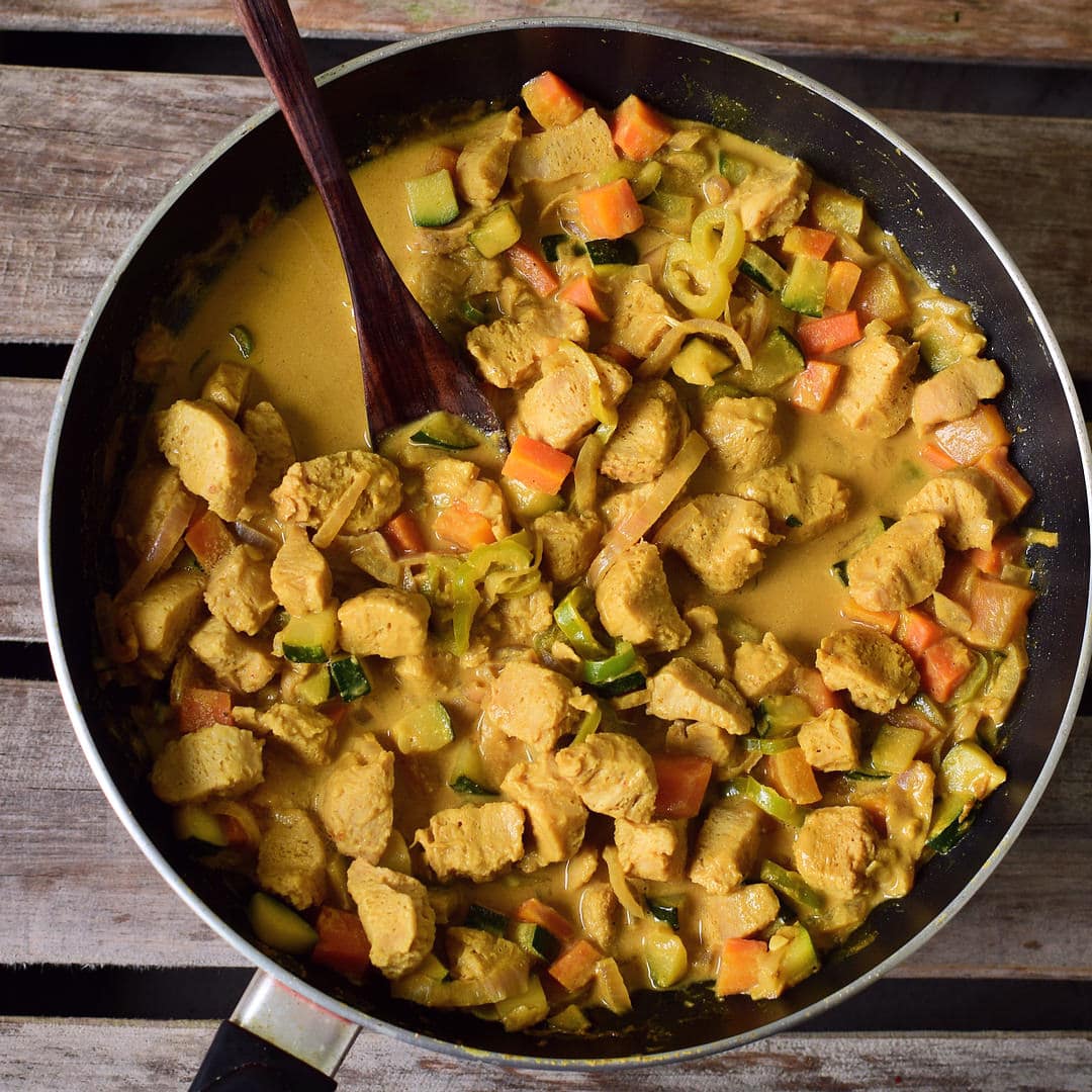 Creamy peanut sauce with veggies and textured soy in a skillet