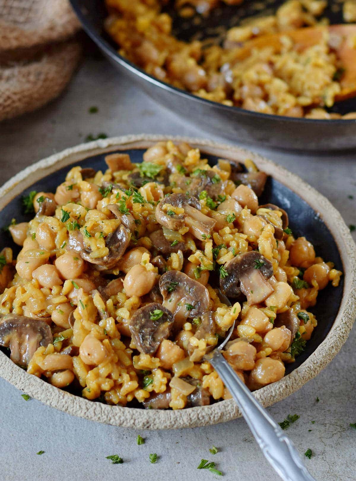 vegan mushroom risotto with chickpeas on a black plate