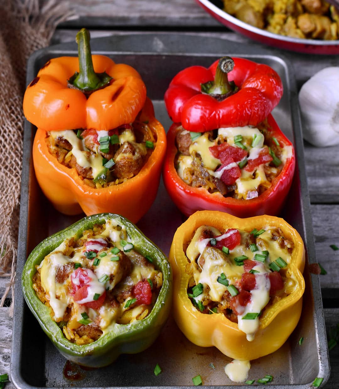 4 baked vegan stuffed bell peppers with plant-based cheese, rice, textured soy protein and veggies