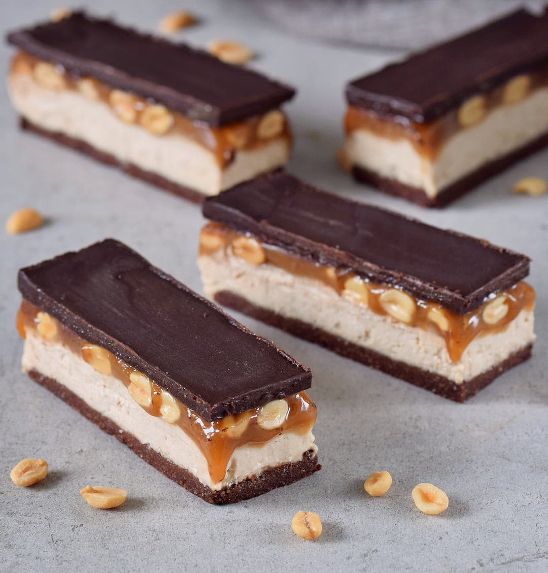 Gluten-free snickers bars with a brownie base, cashew cream, peanut caramel and dairy-free chocolate