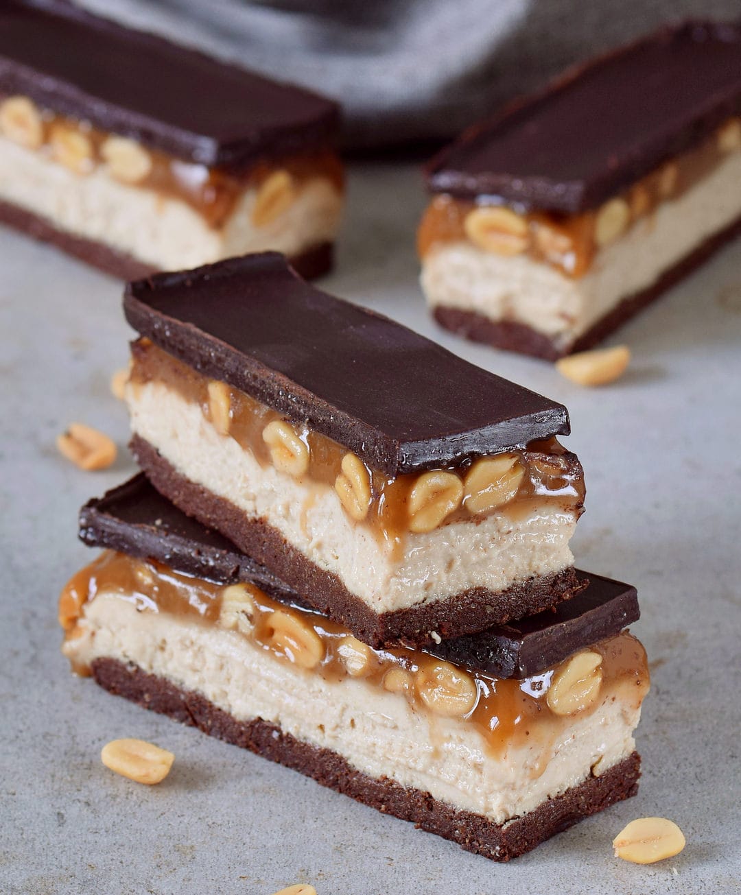 Close-up of vegan snickers bars with a brownie base, cashew cream, peanut caramel and dairy-free chocolate