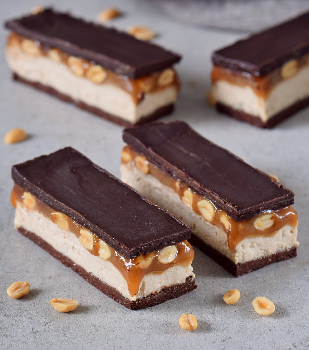 Peanut caramel chocolate bars with a brownie base and cashew cream