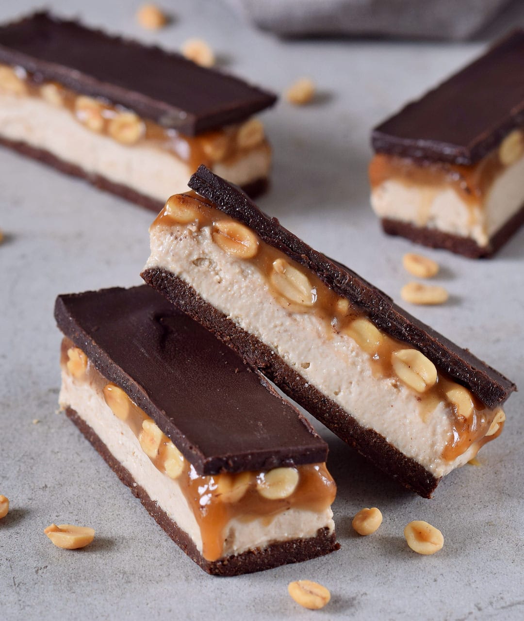 gluten-free snickers bars with a brownie base, cashew cream, peanut caramel and dairy-free chocolate