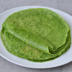 Stack of homemade spinach tortillas on a white plate