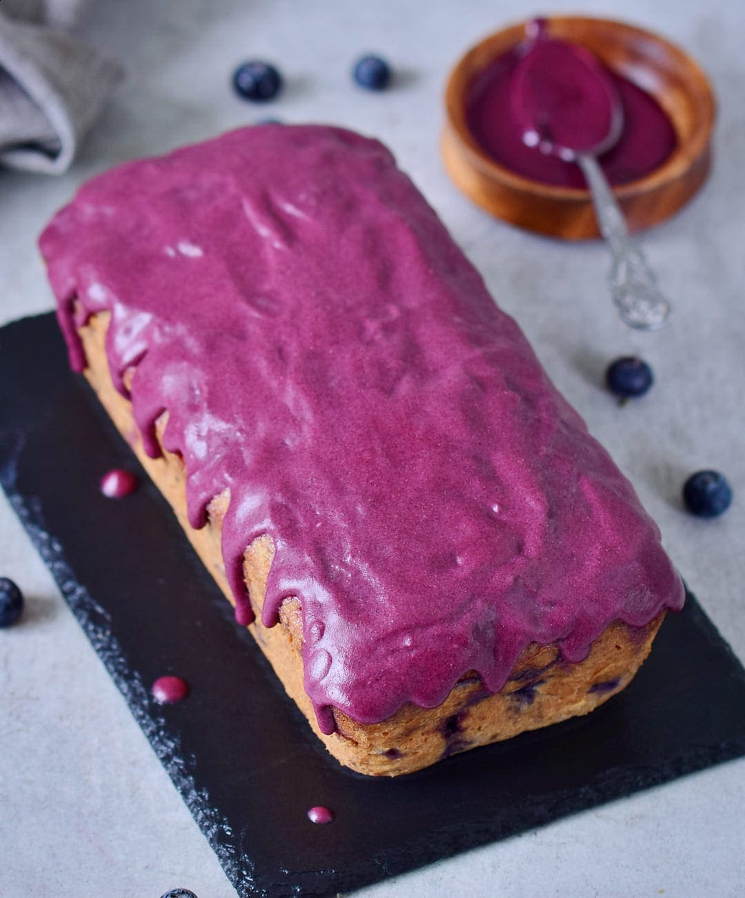 loaf of blueberry banana bread with purple frosting