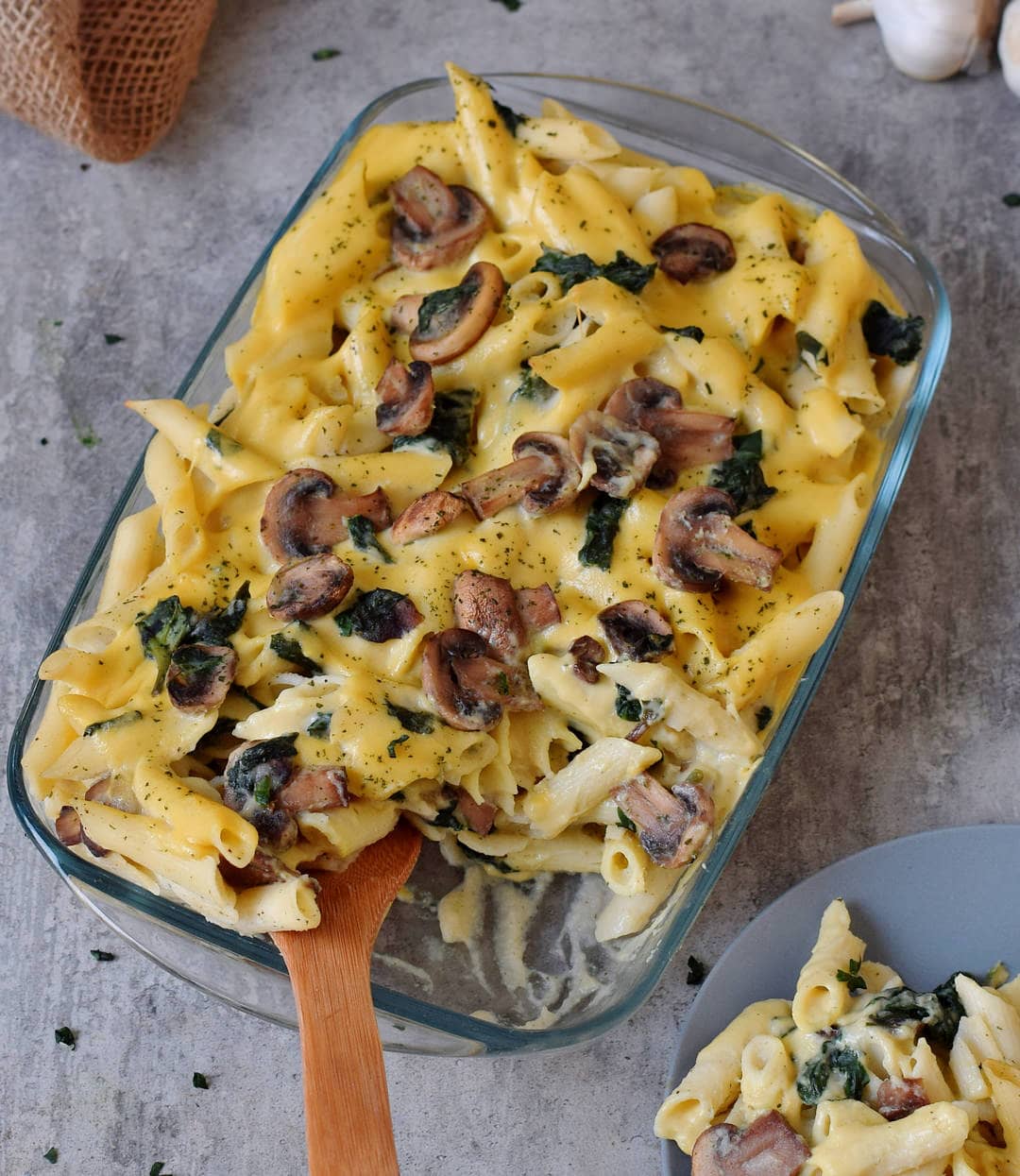Vegan pasta bake with mushrooms and spinach in casserole dish