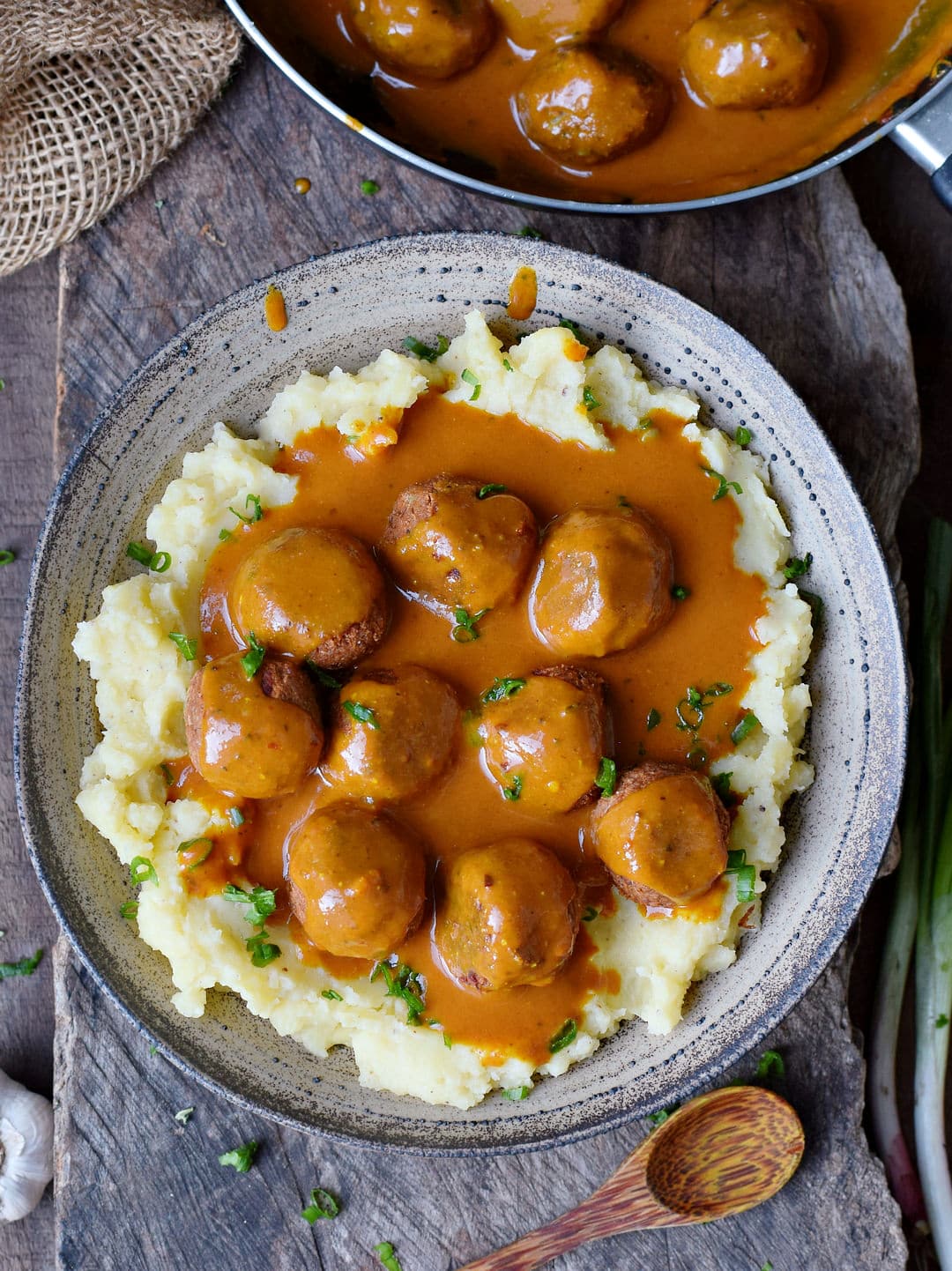 Black bean meatballs in a bowl with curry gravy over mashed potatoes