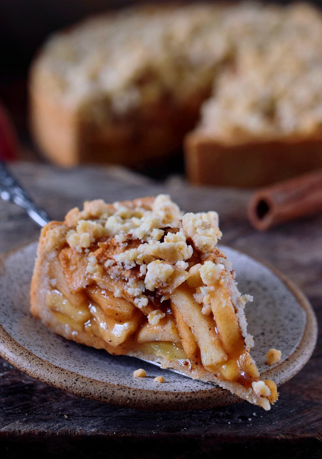 A close up of a piece of vegan apple pie with streusel