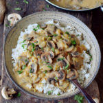 vegan mushroom stroganoff over rice in a bowl with spoon