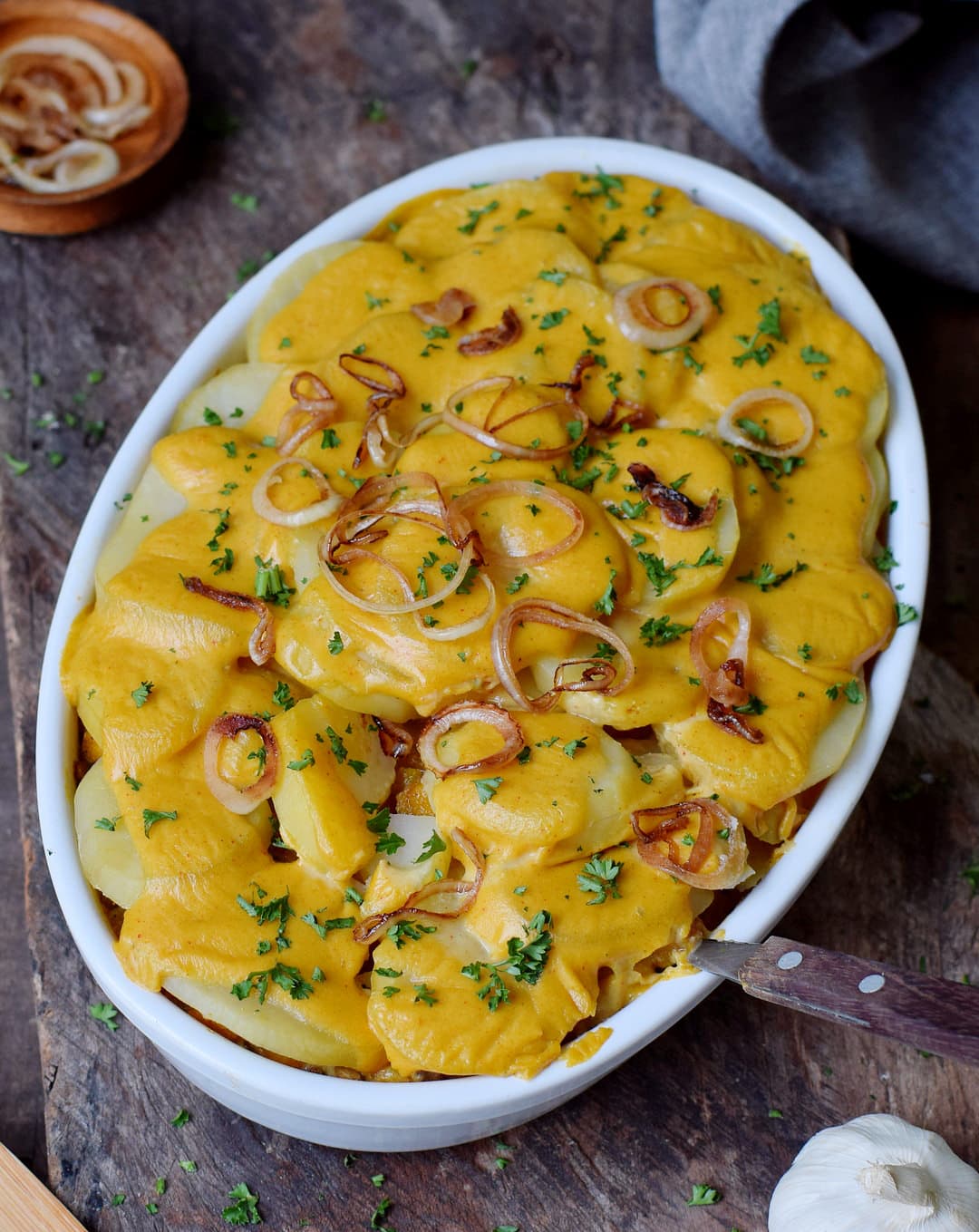 potatoes au gratin in a round baking dish with fried onion rings