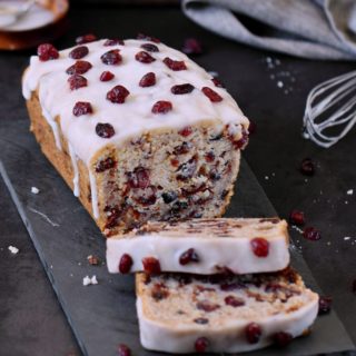 Sliced vegan cranberry bread with sugar-free frosting and dried cranberries