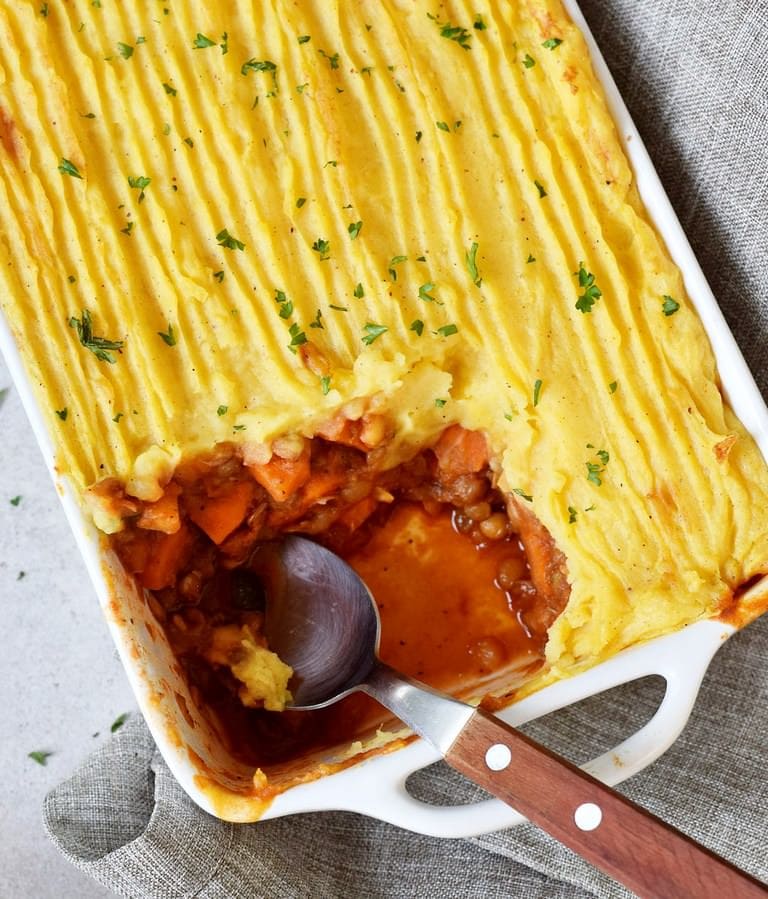 Vegan Shepherds pie in a baking dish with a spoon