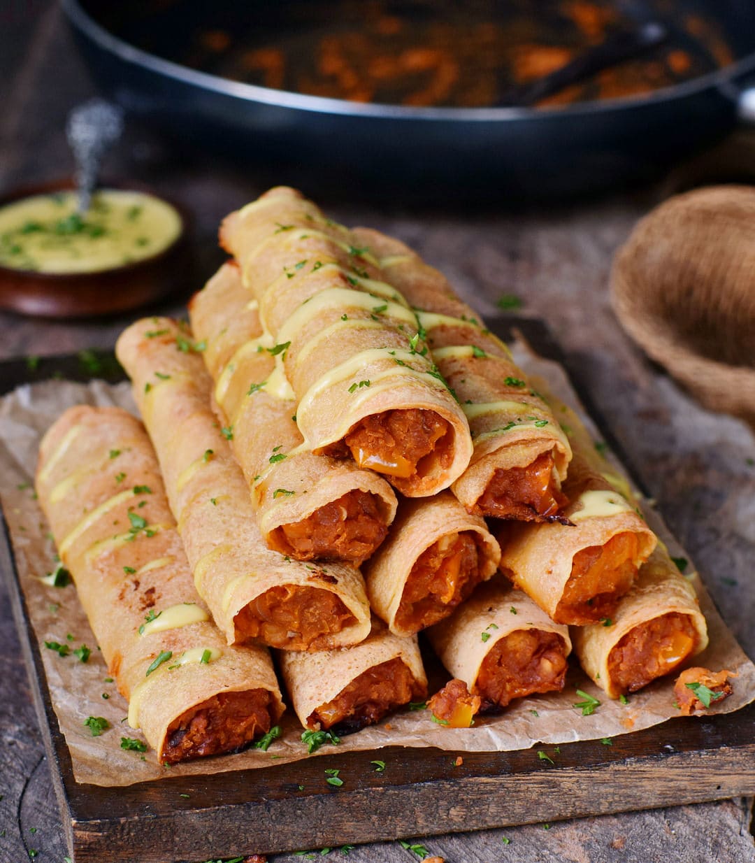 Baked Buffalo chickpea taquitos on a wooden board