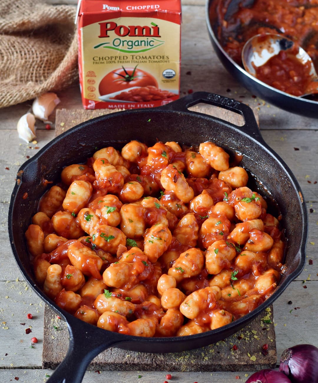 gnocchi all'arrabbiata in a pan with pomi chopped tomatoes