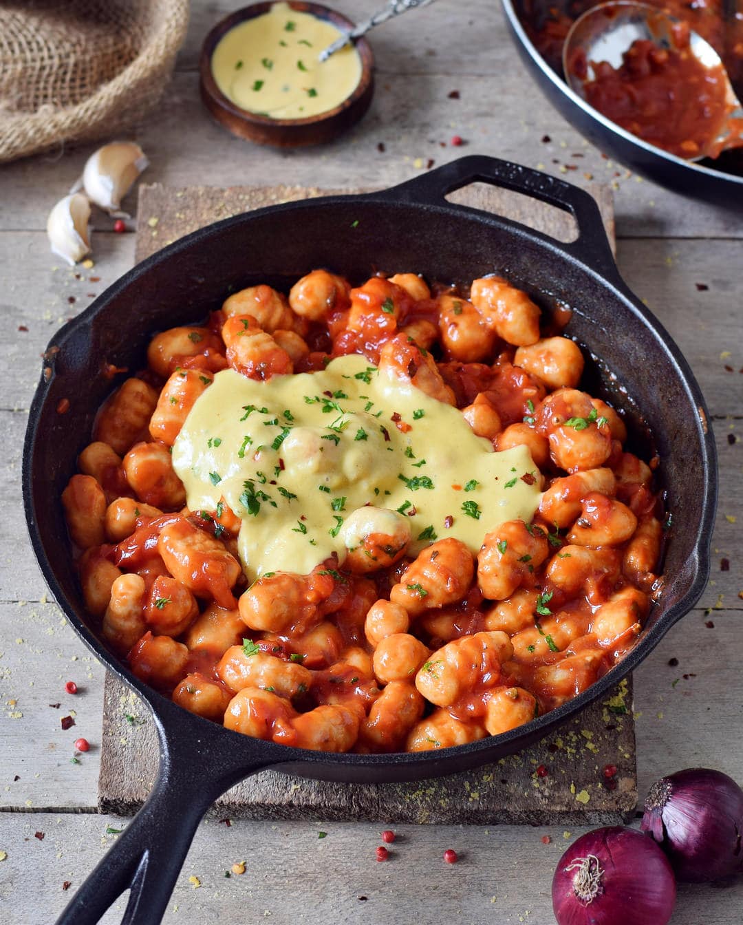 gnocchi all'arrabbiata in a skillet with vegan cheese sauce