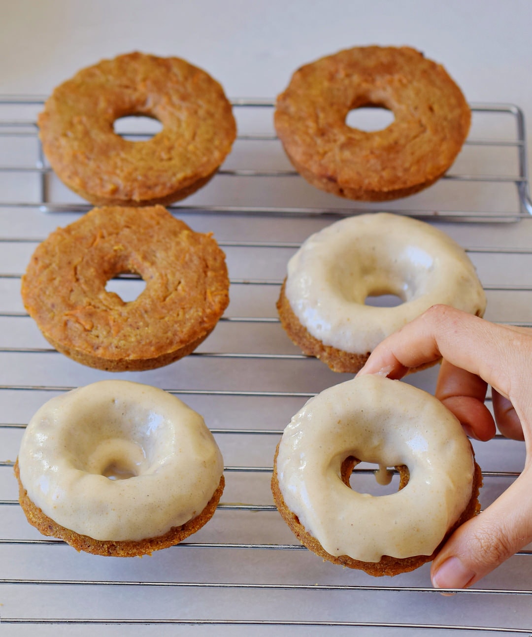 vegan carrot cake donuts with gingerbread flavor and frosting on a wire rack