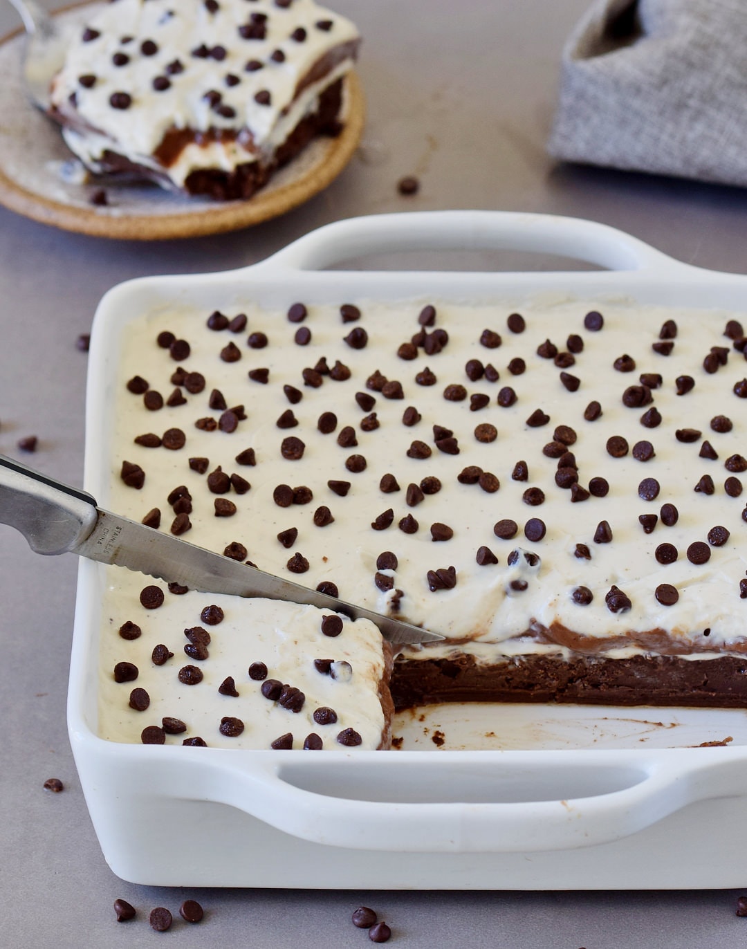 vegan chocolate lasagna in a white baking dish with two pieces cut out